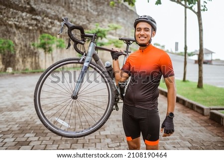 happy smiling road bike cyclist while riding his bike outdoor Royalty-Free Stock Photo #2108190464
