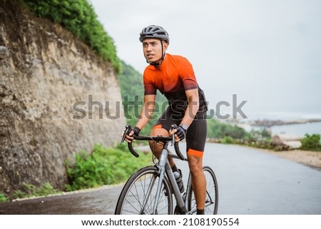 road bike cyclist riding his bike on a cliff Royalty-Free Stock Photo #2108190554