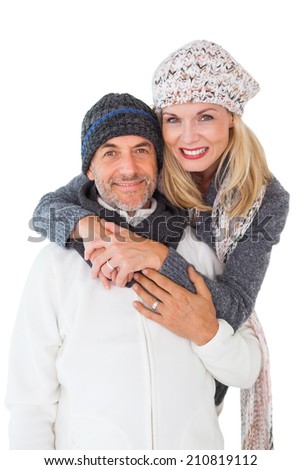 Happy couple in winter fashion embracing on white background