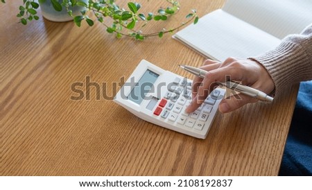 A woman who keeps a household account book. Royalty-Free Stock Photo #2108192837