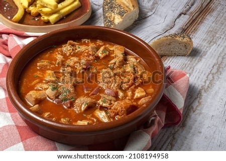 Traditional homemade rabbit meat stew with red wine sauce with aromatic herbs on a black background