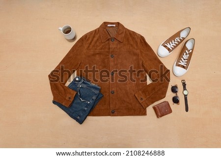Top view of man clothes and accessories on brown background flat lay