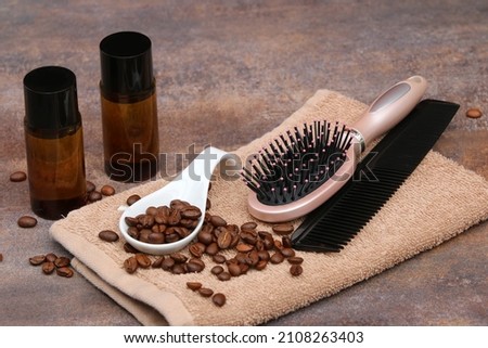 Caffeine shampoo with coffee beans, hairbrush and comb on a towel. Royalty-Free Stock Photo #2108263403