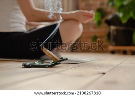 meditating with palo santo aroma stick, mental health Royalty-Free Stock Photo #2108267810