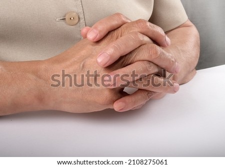 aged woman hand clenched on the desk thinking, make decision, in close shot, body language, gesture