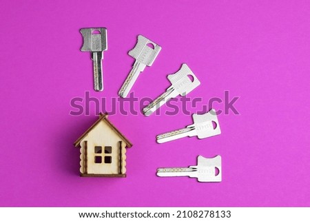 House keys and miniature house model on a colorful bright background. Top view. Home buying concept. Fashionable colorful photo. Trendy flat lay concept.
