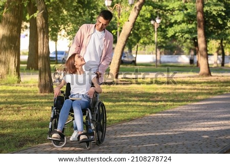 Young woman with physical disability and her husband in park Royalty-Free Stock Photo #2108278724