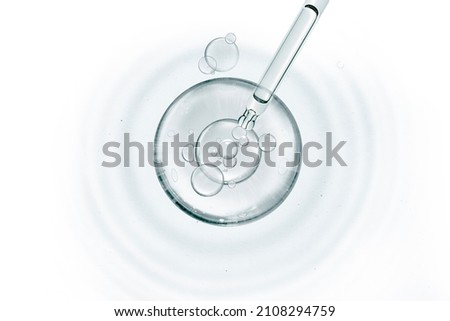 water miracle bubble or cosmetic liquid serum drops with laboratory glass pipette and ripple wave suface abstract background. Beauty and skincare Royalty-Free Stock Photo #2108294759