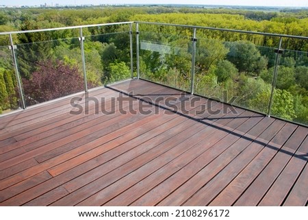 Contemporary architecture appartment balcony view with exotic cumaru wood decking of grooved surface timber and glass railing Royalty-Free Stock Photo #2108296172