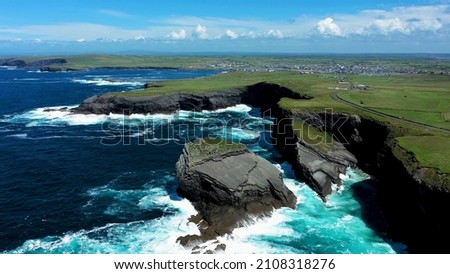 Ireland nature rock stone atlantic ocean water waves foam stream green grass town background blue sky white clouds breathtaking picture shot by drone irish environment coastline travel top view