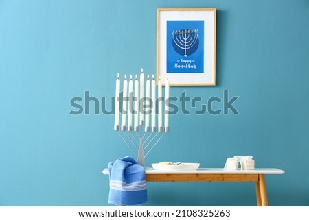 Menorah on table in room decorated for Hanukkah celebration