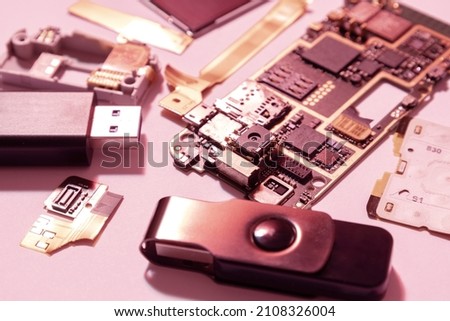 Closeup of many devices parts,cards,flash memory,usb flash drivers on the bright background.Red colors
