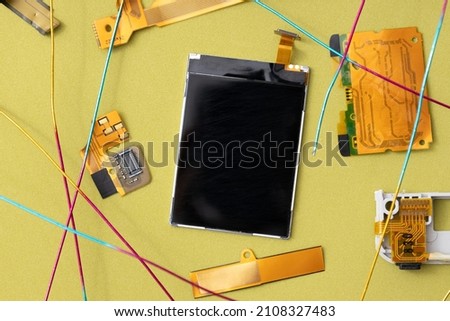 Top view of dark screen part of device,golden details,wires on the green surface.Template for techonology, repair process, security information