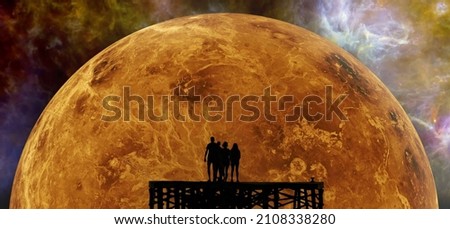 Silhouettes of people against the backdrop of a giant orange planet and exploding space. Elements of this image were furnished by NASA