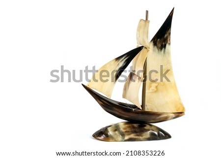 Homemade model of the ship on a white background. A model of a sailboat made of animal horns.