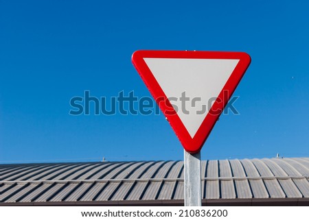 Yield - Give a way sign against blue sky