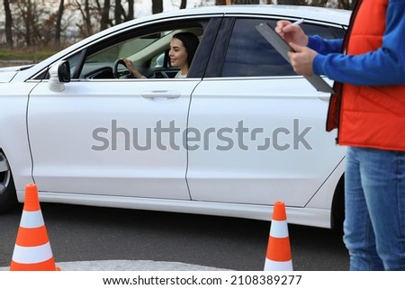 Young woman passing driving school exam at test track