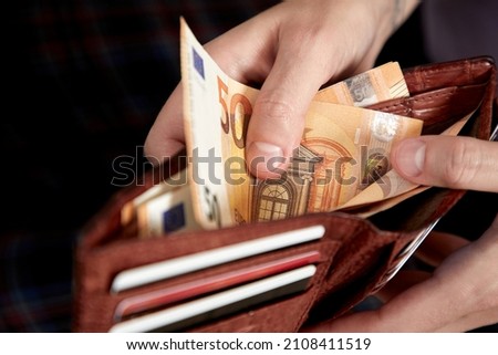 man handing wallet with euro Royalty-Free Stock Photo #2108411519