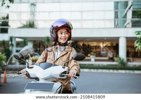 Beautiful woman wearing a helmet while riding a motorcycle Royalty-Free Stock Photo #2108415809