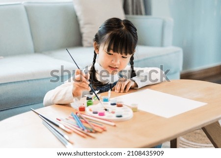 Portrait of a girl sitting and painting at home