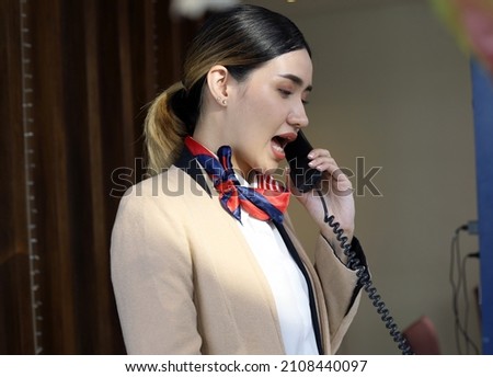 Beautiful Asian reception woman on front at hotel for welcome customer in holiday weekend.