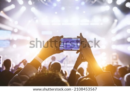 Making video recordings and pics on a smartphone at the concert or light show for publishing on social media