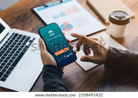 Male executive using smartphone to conduct online mobile banking, investing in stocks and mutual funds, retirement investment ideas. Royalty-Free Stock Photo #2108495432