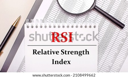 Desktop magnifier, reports, pen and notebook with text RSI Relative Strength Index. Business concept