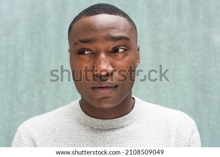 Close up portrait African American man glancing by green background Royalty-Free Stock Photo #2108509049