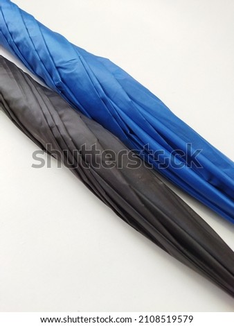 Folded umbrella with blue and black color on isolated white background
