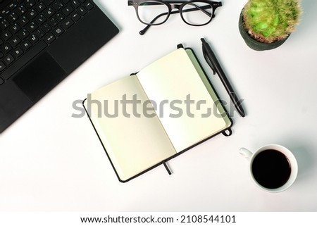 Top view of a notebook, laptop, glasses and coffee cupon a white background. Copy space, business concept