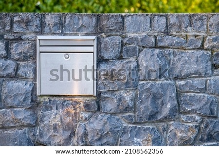 Mailboxes mounted at entry gates, mailboxes embedded in a stone wall, stylish mailboxes. Royalty-Free Stock Photo #2108562356