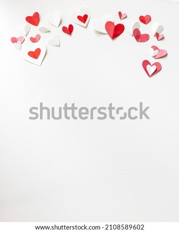 Valentines Day or wedding, invitation, scattered painted small cut out red, pink and white hearts, vertical with copy space