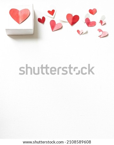 Valentines Day gift box, scattered painted small cut out red, pink and white hearts, vertical with vertical copy space