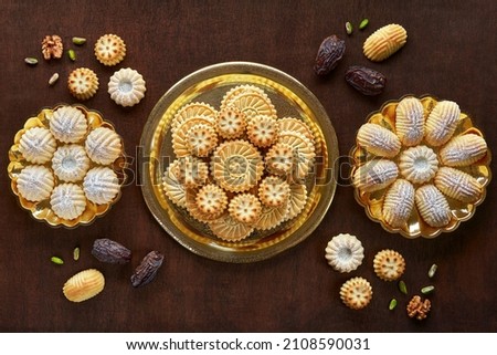 Assorted semolina maamoul or mamoul cookies with dates , walnuts and pistachio nuts. Traditional arabic Eid al Adha, Eid al Fitr sweets   . Top view, flat lay Royalty-Free Stock Photo #2108590031