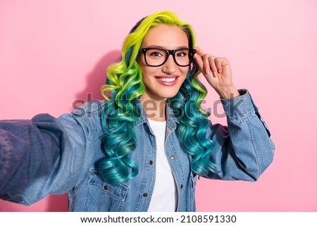 Self-portrait of attractive cheerful intelligent wavy-haired girl touching specs isolated over pink pastel color background