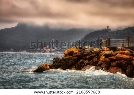 the sea water breaks on the rocks of a cliff on the coast of western Liguria in Italy