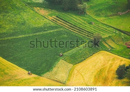 Norway. Amazing Summer Scenic Aerial View Of Norwegian Fields With Working Tractors In Summer Countryside Fields Rural Landscape. Norway. Amazing Summer Scenic Aerial View Of Norwegian Fields With