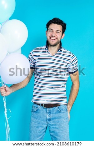 Caucasian Man Celebrating Anniversary of Business Company Aa a Part of Corporate Party While Carrying Colorful Airballoons Casual Clothing Against Blue Background. Vertical Image