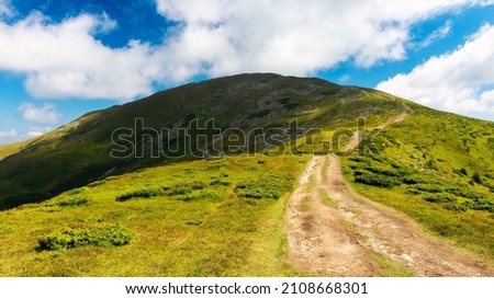 trail uphill the petros peak. beautiful summer landscape of carpathian mountains. success and achievement concept. grassy hill beneath a sky with clouds Royalty-Free Stock Photo #2108668301