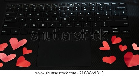 Red painted folded hearts on a laptop keyboard, concept love in the workplace copy space