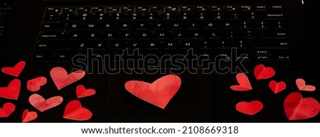 Red painted folded hearts on a laptop keyboard, concept love in the workplace copy space