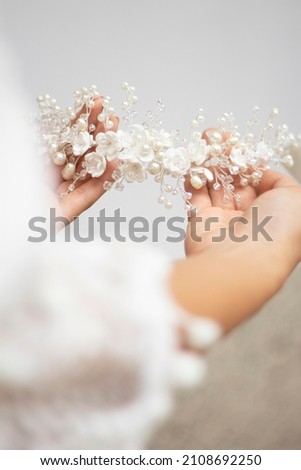 bride hands hold wedding hair accesory with white flowers. jewelry for bride. headpiece for bride. tiara Royalty-Free Stock Photo #2108692250