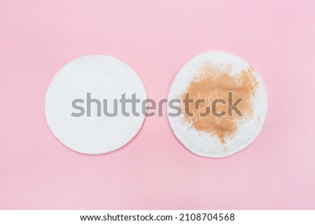 Two cotton pads for makeup dirty and clean on a pink background. Dirty and clean cosmetic pad after removing make-up. Hygiene concept Royalty-Free Stock Photo #2108704568