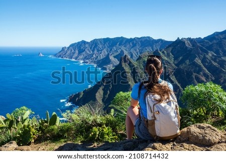 Woman hiker watching beautiful costal scenery. - Tenerife, Canary Islands, Spain. coast view, mountain Anaga Royalty-Free Stock Photo #2108714432