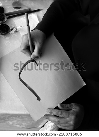 Woman writing arabic alphabet, calligrapher, islamic alphabet