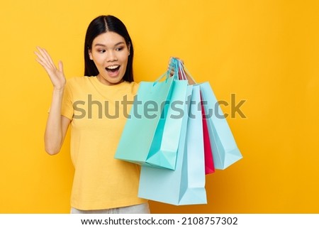 woman with Asian appearance with packages in hands shopping isolated background unaltered