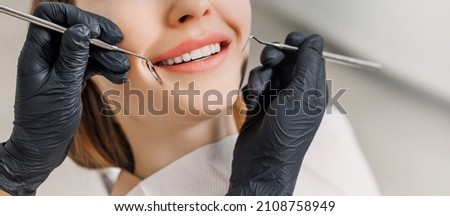 Banner for dental theme. Close-up of female smile with white teeth during medical examination. Concept of tooth whitening, treatment, veneers, professional clinic. Photo with free copy space. Royalty-Free Stock Photo #2108758949