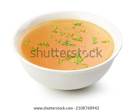 bowl of chicken broth with chopped green onions isolated on white background