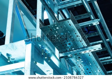 Metal cable tray close up. Metal frames for wiring and equipment. Cable trays at the enterprise. Cable-carrying systems made of steel. Metal perforated tray for laying cable routes Royalty-Free Stock Photo #2108786327
